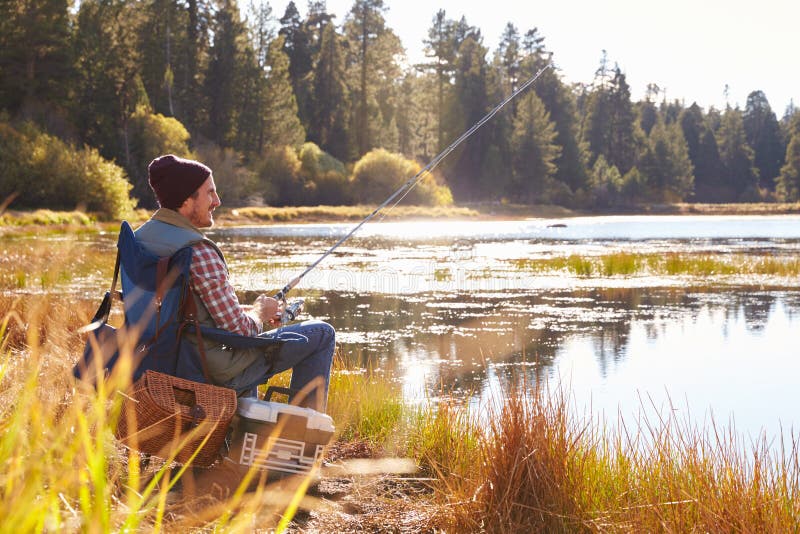 Mid-adult man fishing by lakeside, Big Bear, California, USA. Mid-adult man fishing by lakeside, Big Bear, California, USA