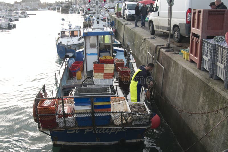 Рыболовы разгружают коробки со свежими морепродуктами whelk задвижки от рыбацкой лодки стоковое фото Рыболовы разгружают коробки со свежими морепродуктами whelk задвижки от рыбацкой лодки стоковое фото