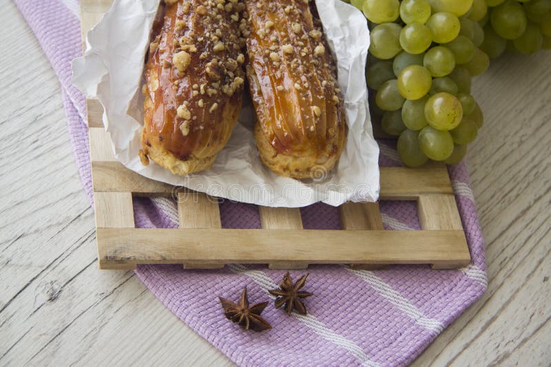 Сладостные eclairs и зеленые виноградины стоковые фото Сладостные eclairs и зеленые виноградины стоковые фото