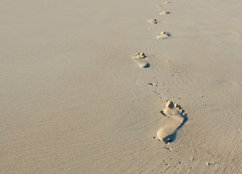 Walking alone - footprints in the sand. Walking alone - footprints in the sand