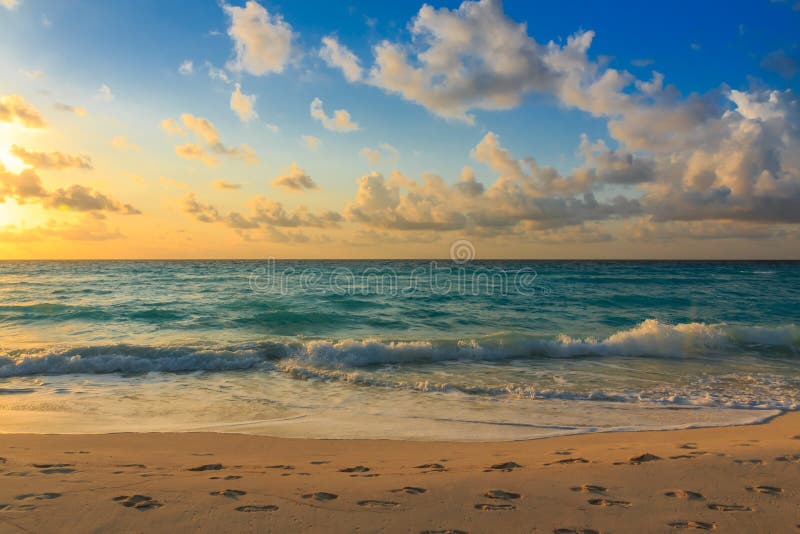 Sunrise on the beach in Cancun, Mexico showing footprints in the sand. Sunrise on the beach in Cancun, Mexico showing footprints in the sand