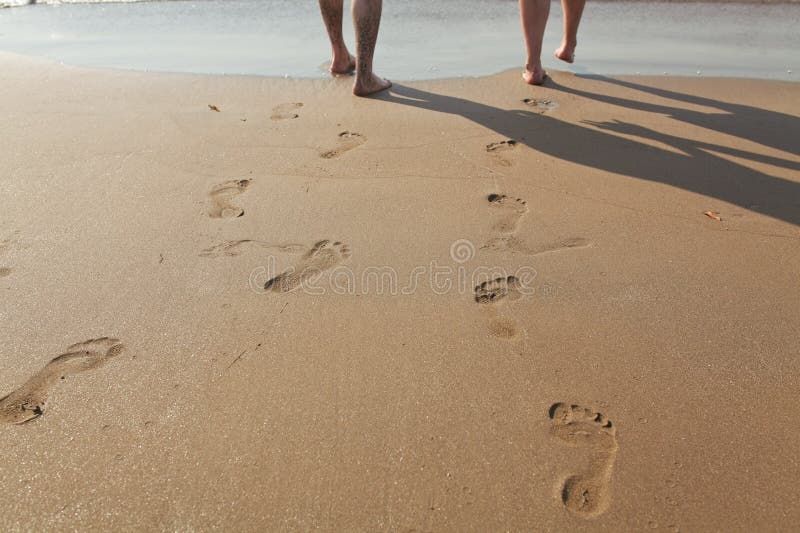 Footprints in wet sand of man and a woman. Footprints in wet sand of man and a woman.