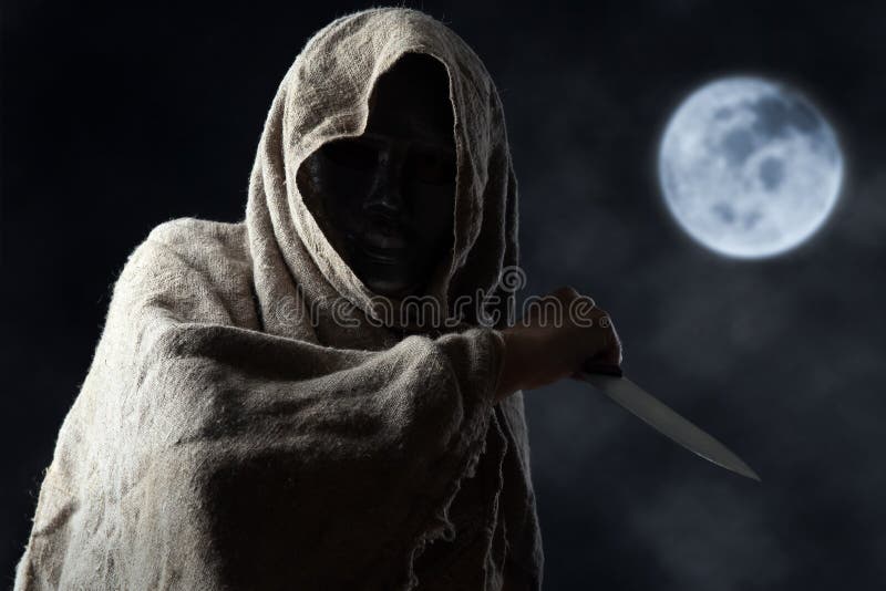 The hooded man in mask with a big knife. The hooded man in mask with a big knife