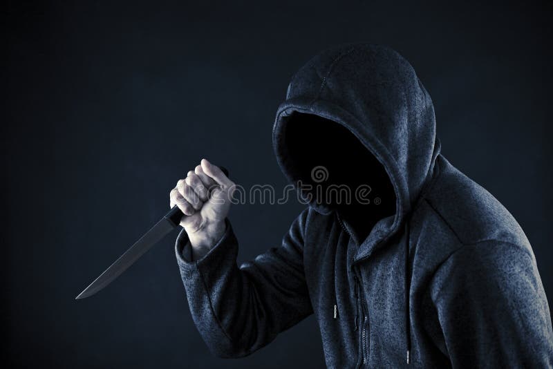 Hooded man with knife in the dark. Hooded man with knife in the dark