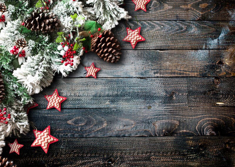 Merry Christmas Frame with green pine, colorful baubles, knots with berries,stars and other seasonal stuff over an old wooden aged background. Merry Christmas Frame with green pine, colorful baubles, knots with berries,stars and other seasonal stuff over an old wooden aged background