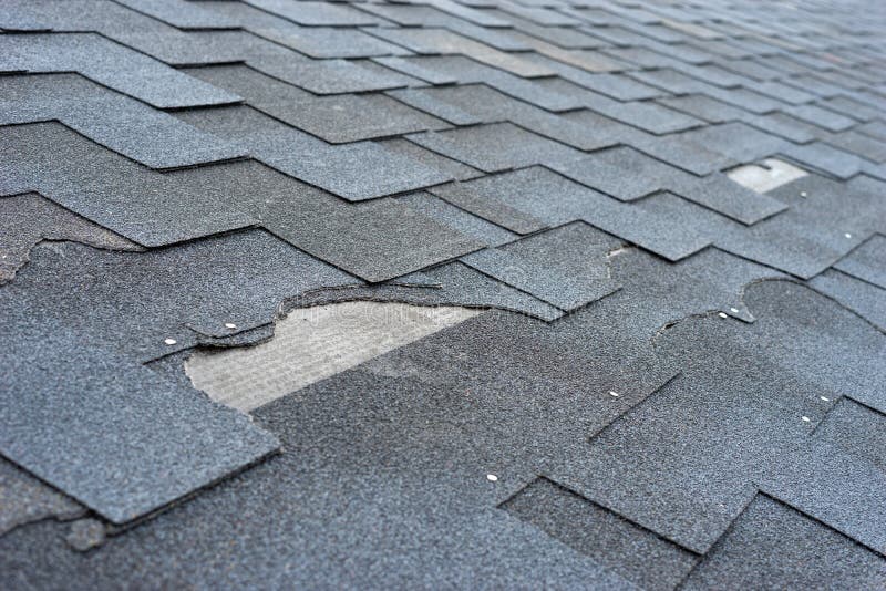 Сlose w górę widoku asfaltowa gontu dachu szkoda która potrzebuje naprawę