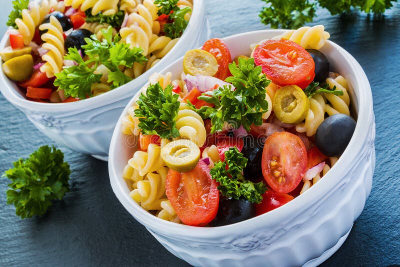 Салат: fusilli макаронных изделий, черные и зеленые оливки, томаты вишни, красный лук и петрушка стоковая фотография Салат: fusilli макаронных изделий, черные и зеленые оливки, томаты вишни, красный лук и петрушка стоковая фотография