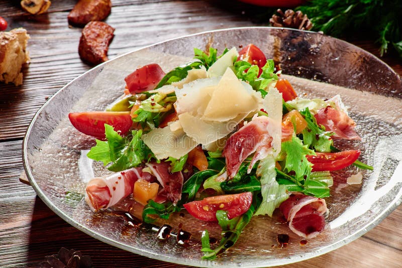 Салат с ветчиной, томатами, сыром, arugula и шпинатом в прозрачной плите стоковые изображения Салат с ветчиной, томатами, сыром, arugula и шпинатом в прозрачной плите стоковые изображения