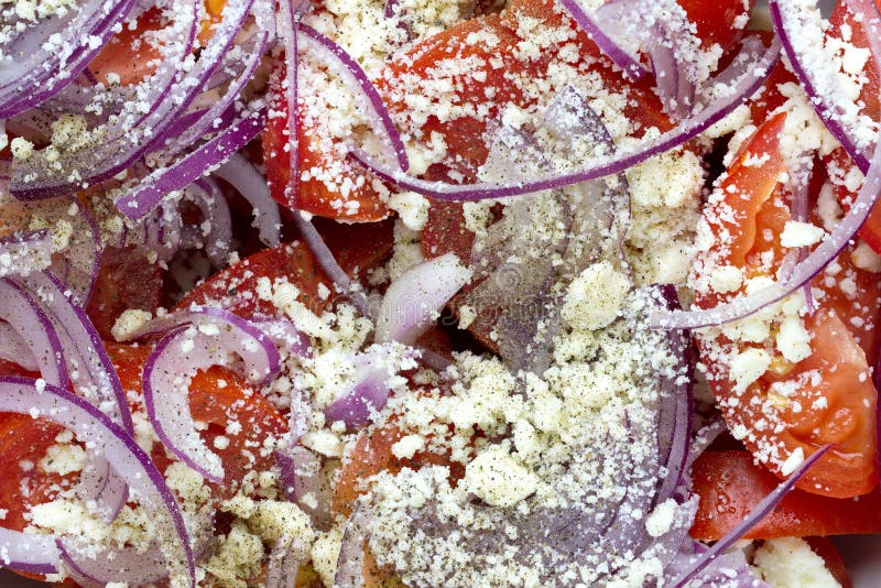 Салат с свежими томатами, красным луком и заскрежетанным сыром фета стоковая фотография Салат с свежими томатами, красным луком и заскрежетанным сыром фета стоковая фотография