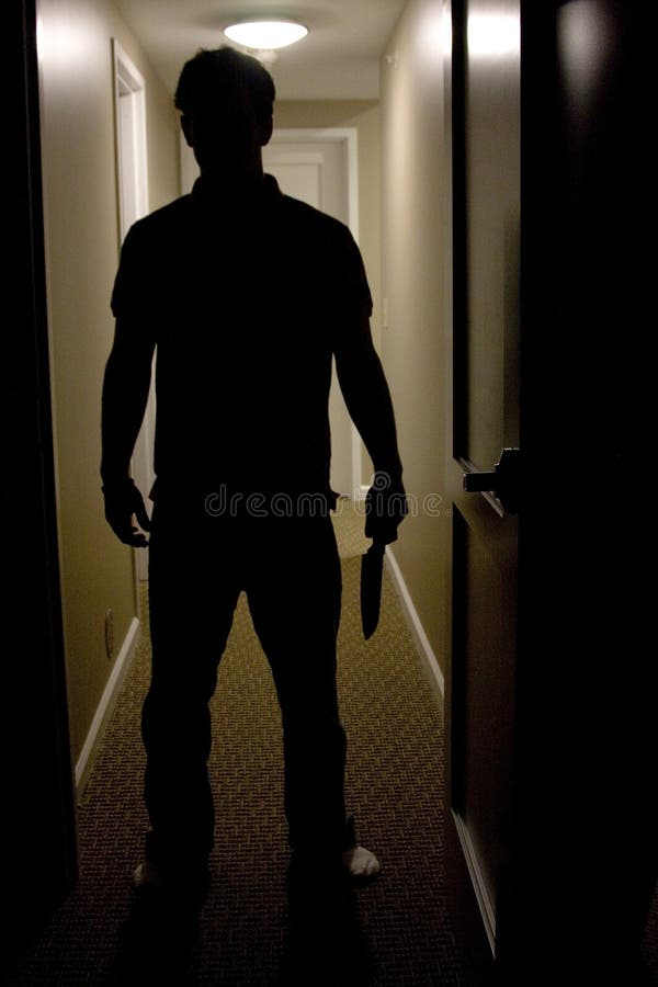 A mans silhouette is shown coming into a dark room holding a knife. A mans silhouette is shown coming into a dark room holding a knife.