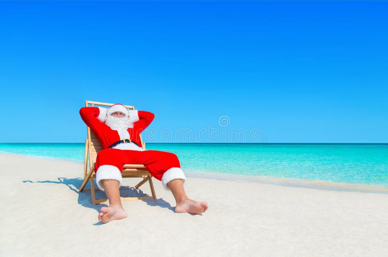 Санта Клаус ослабляет в sunlounger на песочном тропическом пляже моря стоковое фото
