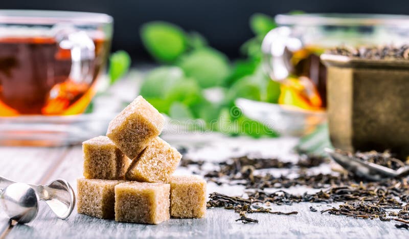 сахар Тростниковый сахар Конец кучи кубов тростникового сахара вверх по съемке макроса Чай в стеклянной чашке, листья мяты, высуш стоковые изображения сахар Тростниковый сахар Конец кучи кубов тростникового сахара вверх по съемке макроса Чай в стеклянной чашке, листья мяты, высуш стоковые изображения