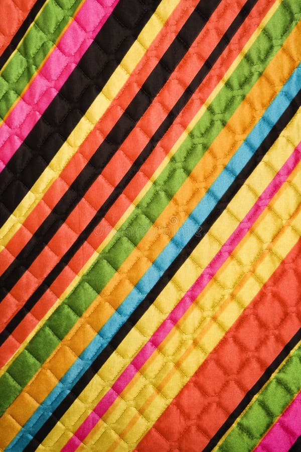 Close-up of bright colorful striped quilted vintage fabric. Close-up of bright colorful striped quilted vintage fabric.