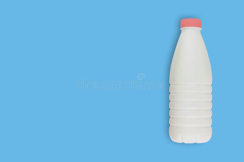 Свежая бутылка молочного продучта полностью пластиковая для молока, кефира или йогурта с красной крышкой на голубой таблице на ку стоковое фото Свежая бутылка молочного продучта полностью пластиковая для молока, кефира или йогурта с красной крышкой на голубой таблице на ку стоковое фото