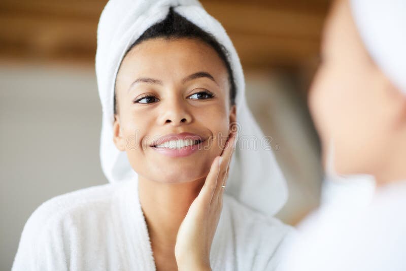 Head and shoulders portrait of  smiling Mixed-Race woman looking in mirror during morning routine, copy space. Head and shoulders portrait of  smiling Mixed-Race woman looking in mirror during morning routine, copy space