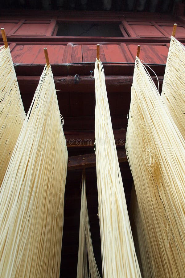 Fresh noodle drying on drying rack, in front of traditional asian house. Fresh noodle drying on drying rack, in front of traditional asian house