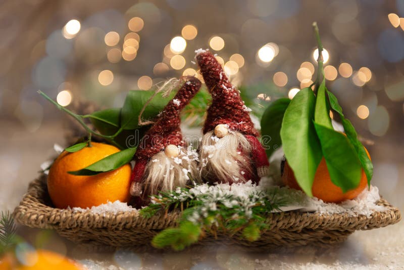 Fresh Clementines or Tangerines and 2 Gnomes with Xmas Lights on the background, Christmas concept. Fresh Clementines or Tangerines and 2 Gnomes with Xmas Lights on the background, Christmas concept