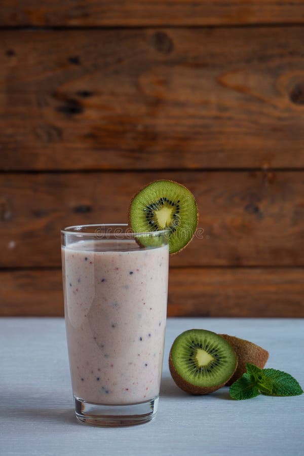 Свежие домодельные smoothies с кивиом, бананом, молоком, и мятой Здоровое органическое питье На белом деревянном столе стоковые изображения Свежие домодельные smoothies с кивиом, бананом, молоком, и мятой Здоровое органическое питье На белом деревянном столе стоковые изображения
