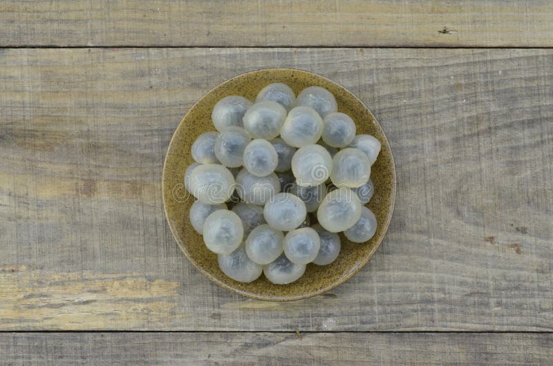 Свежий longan в коричневой плите на деревянном столе стоковые изображения Свежий longan в коричневой плите на деревянном столе стоковые изображения