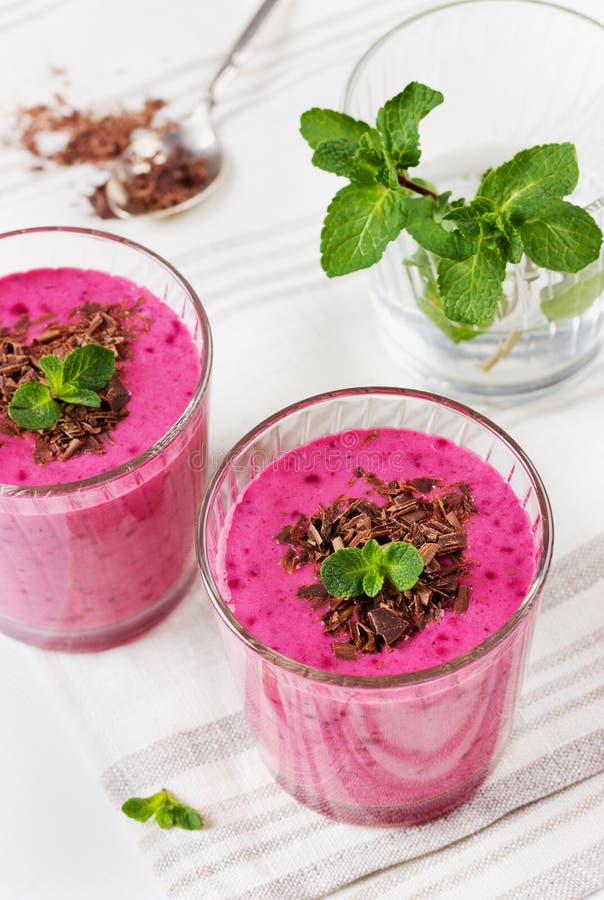 Свежий smoothie ягоды, milkshake, югурт, украшенные десертом заскрежетанные шоколад и мята стоковые фотографии rf