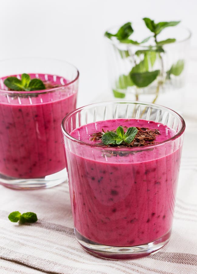 Свежий smoothie ягоды, milkshake, югурт, украшенные десертом заскрежетанные шоколад и мята стоковая фотография
