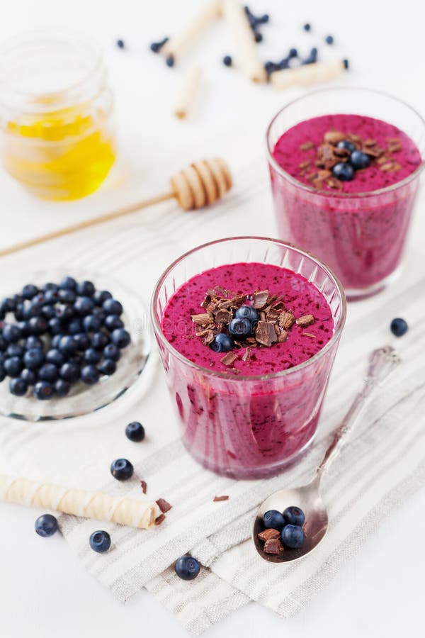 Свежий smoothie ягоды, milkshake, югурт, украшенный десерт заскрежетал шоколад, мед и голубику стоковое изображение rf