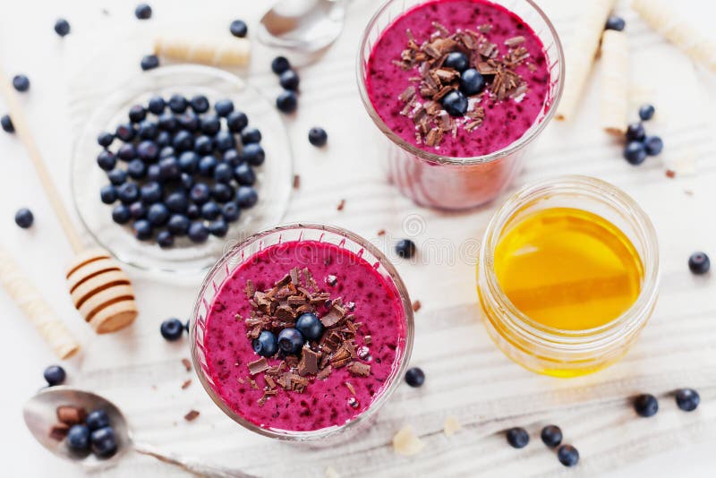 Свежий smoothie ягоды, milkshake, югурт, украшенный десерт заскрежетал шоколад, мед и голубику стоковые изображения