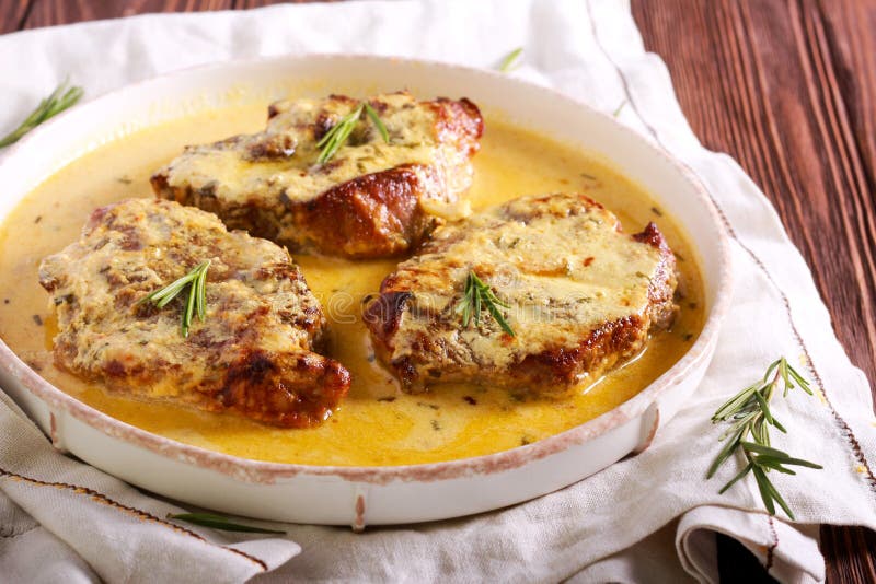 Rosemary pork chops in creamy sauce on plate. Rosemary pork chops in creamy sauce on plate