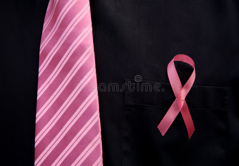 Pink textured men's tie and symbolic pink ribbon for breast cancer awareness is shown on a black dress shirt. Pink textured men's tie and symbolic pink ribbon for breast cancer awareness is shown on a black dress shirt.