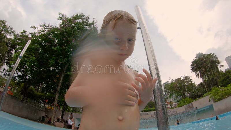 Сдвиг, когда маленький мальчик весело проводит время в бассейне в парке