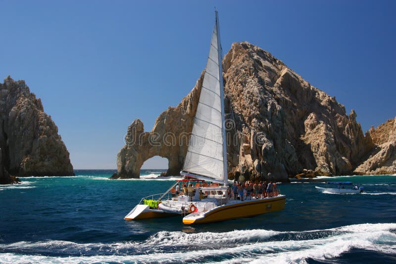 A catamaran sails past the landmark Los Arcos rock formation at Land's End in Cabo San Lucas, Mexico. A catamaran sails past the landmark Los Arcos rock formation at Land's End in Cabo San Lucas, Mexico.