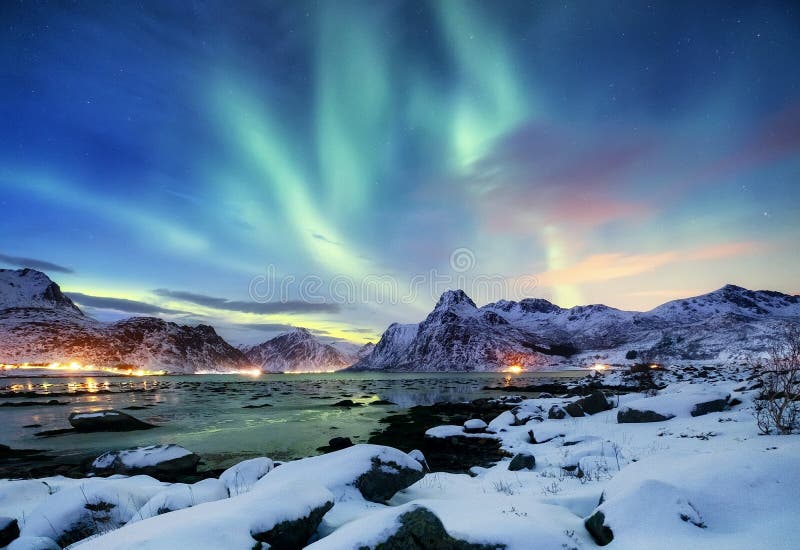 Aurora borealis on the Lofoten islands, Norway. Green northern lights above mountains. Night sky with polar lights. Night winter landscape with aurora and reflection on the water surface. Natural background in the Norway. Aurora borealis on the Lofoten islands, Norway. Green northern lights above mountains. Night sky with polar lights. Night winter landscape with aurora and reflection on the water surface. Natural background in the Norway