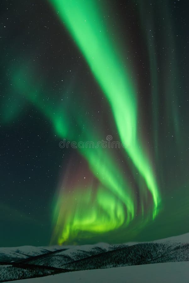 Aurora Borealis rising from the snow covered mountains. Aurora Borealis rising from the snow covered mountains