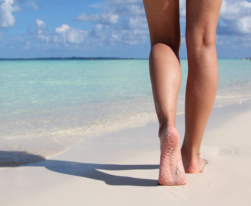 Legs on Tropical Sand Beach. Walking Female Feet. Closeup. Legs on Tropical Sand Beach. Walking Female Feet. Closeup