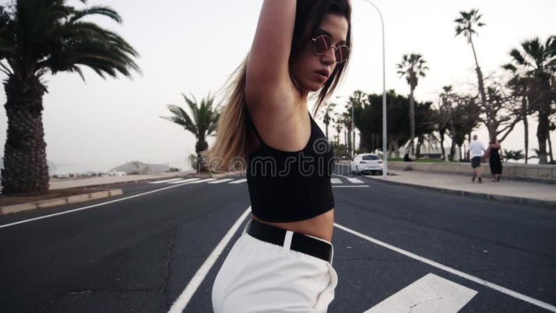 Сексуальная девушка с twerk прекрасного тела, танцующий в районе курорта тропической прямо на дороге. Девушка в солнечных очках пе сток-видео