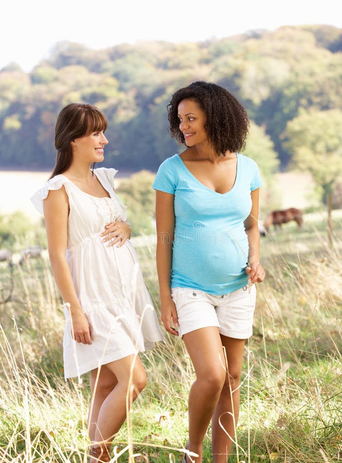 Pregnant women outdoors in countryside talking and walking. Pregnant women outdoors in countryside talking and walking