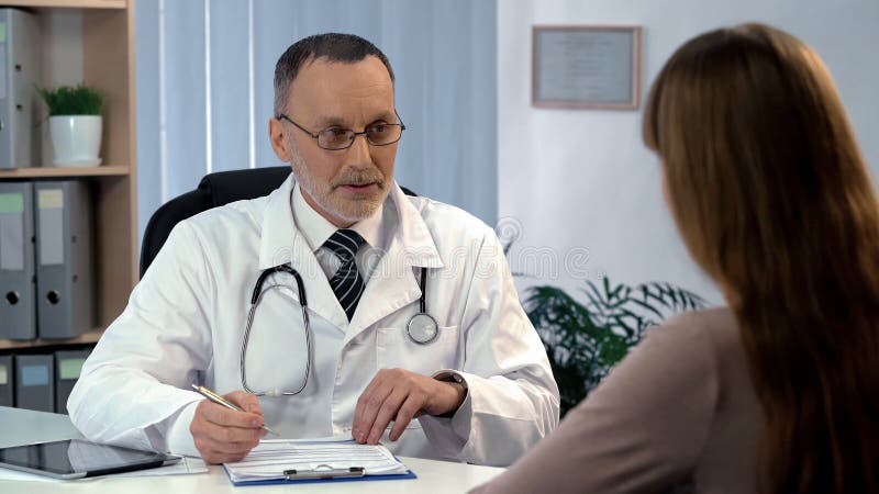 Семейный врач слушая к пациенту, заполняя вне медицинское страхование, здравоохранение стоковые фотографии rf Семейный врач слушая к пациенту, заполняя вне медицинское страхование, здравоохранение стоковые фотографии rf