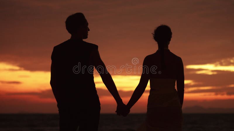 семейный концерт. мужчина и женщина, влюбленные, держат за руки по вечерам на закате в море. мужчина видит мечту со своим