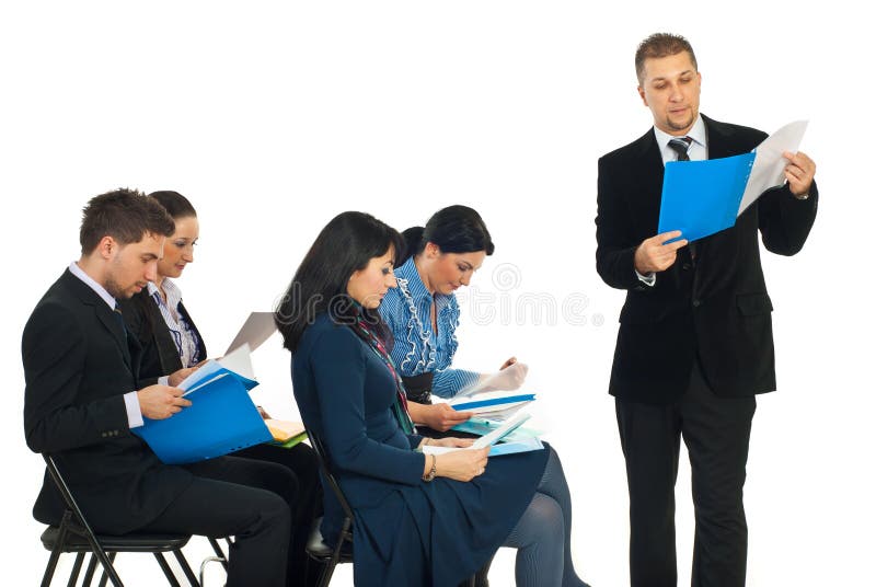 Business man reading from a folder at seminar and his colleagues business people checking their folders over white background. Business man reading from a folder at seminar and his colleagues business people checking their folders over white background