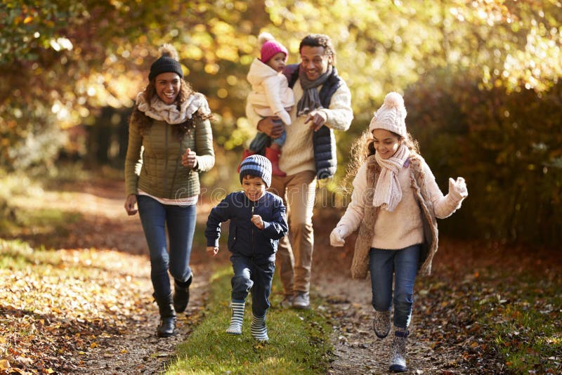 Family Running Along Path Through Autumn Countryside. Family Running Along Path Through Autumn Countryside