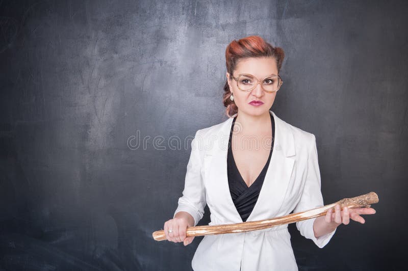 Angry teacher with wooden stick on chalkboard blackboard background. Angry teacher with wooden stick on chalkboard blackboard background