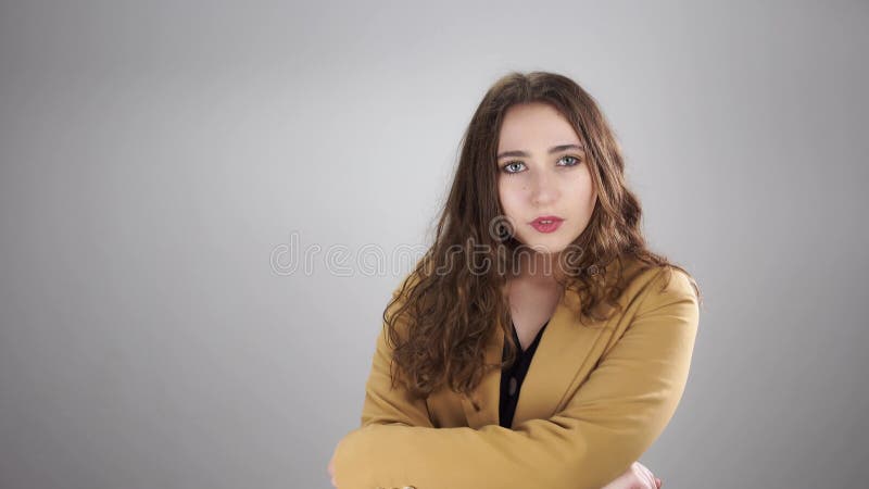 серьёзная молодая женщина бросает в воздух кучу наличных долларовых купюр и скрещивает руки на груди сток-видео