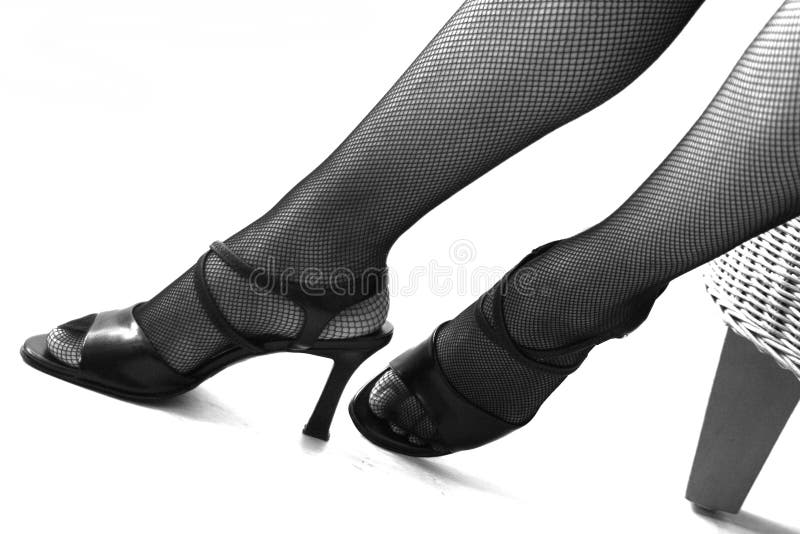 Fish net stockings on legs with high heels in black and white. With copy space. Fish net stockings on legs with high heels in black and white. With copy space.