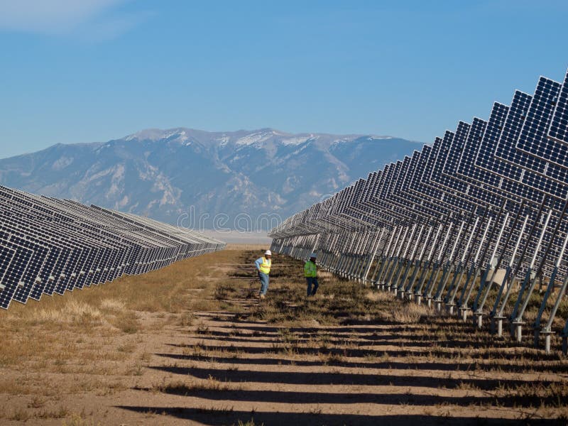 A series of large solar panels forms a symmetrical line at a power plant in the San Luis Valley of central Colorado. These panels utilize a tracking system to follow the sun, collecting its energy and using photovoltaic cells to transform the sunlight into electricity. A series of large solar panels forms a symmetrical line at a power plant in the San Luis Valley of central Colorado. These panels utilize a tracking system to follow the sun, collecting its energy and using photovoltaic cells to transform the sunlight into electricity.