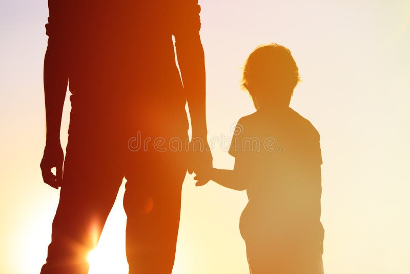 Silhouette of father and son holding hands at sunset sky. Silhouette of father and son holding hands at sunset sky