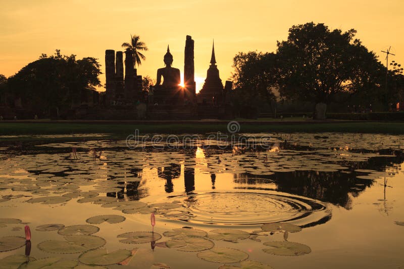 Силуэт старой статуи и пагод Будды против неба захода солнца на Sukhothai, Таиланде стоковое фото rf Силуэт старой статуи и пагод Будды против неба захода солнца на Sukhothai, Таиланде стоковое фото rf