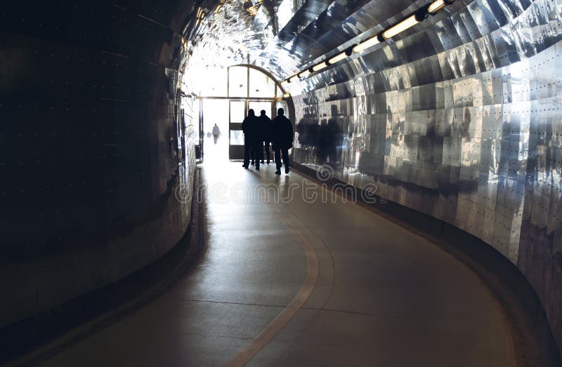 Silhouettes at the end of a tunnel for pedestrians and cyclists in Stockholm, Sweden. Silhouettes at the end of a tunnel for pedestrians and cyclists in Stockholm, Sweden.