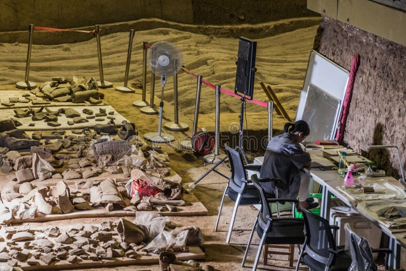 XI'AN, CHINA - AUGUST 6, 2018: Archaeologist working in the Pit 2 of the Army of Terracotta Warriors near Xi'an, Shaanxi province, China. XI'AN, CHINA - AUGUST 6, 2018: Archaeologist working in the Pit 2 of the Army of Terracotta Warriors near Xi'an, Shaanxi province, China