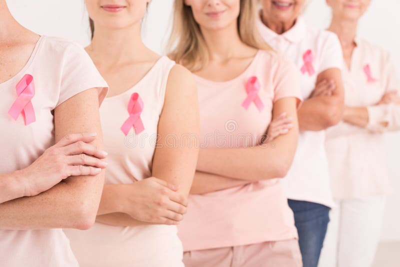 The power to fight breast cancer, women wearing pink ribbons for breast cancer campaign on white background. The power to fight breast cancer, women wearing pink ribbons for breast cancer campaign on white background