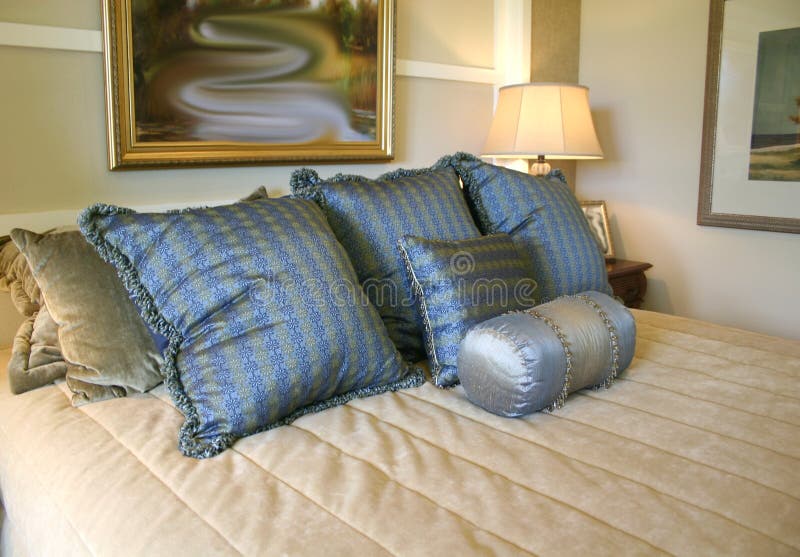 Blue satin pillows on beige quilted bedspread. Blue satin pillows on beige quilted bedspread